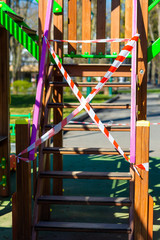 Children's playground closed and wrapped in alarm caution tape for global coronavirus quarantine