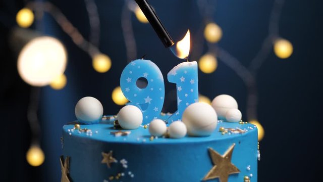Birthday cake number 91 stars sky and moon concept, blue candle is fire by lighter and then blows out. Copy space on right side of screen if required. Close-up and slow motion
