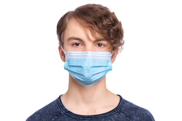 Concept of coronavirus quarantine. Child wearing medical protective mask to health protection from influenza virus, isolated on white background. Portrait of Teen boy in protective face mask.