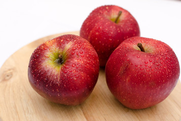 fresh red apples close-up on a light wooden background, healthy health products