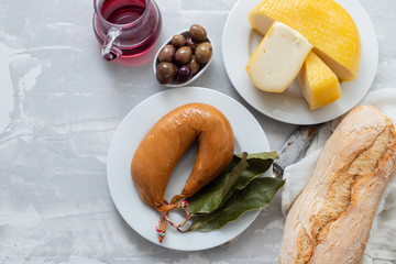typical portuguese smoked sausage farinheira, olives and bread on white dish