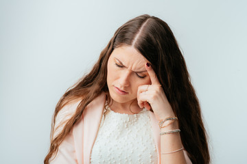 long-haired beautiful brunette girl is tired and has a headache, isolated on a white background