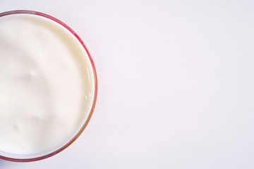 Fresh organic yogurt in a transparent glass. Half beautiful milk yogurt, copyspace for your text on a white background
