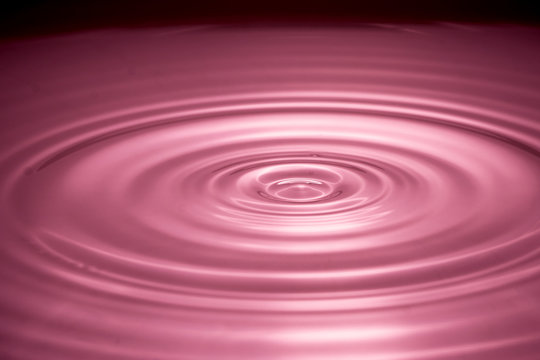 Water drops splash in a glass red colored