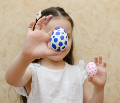 girl with painted eggs for easter, boy or girl, expectation, child in a white t-shirt, hands closeup