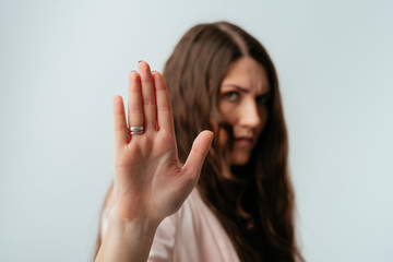 long-haired beautiful brunette girl shows stop, isolated on a white background