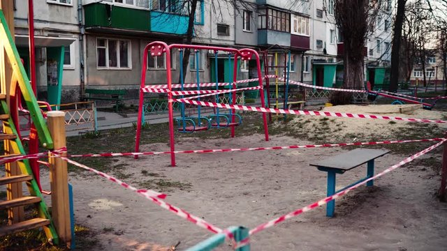 An empty abandoned playground fenced with ribbons in a residential area during quarantine due to the threat of AKA covid-19 coronavirus. Ukraine, Sumy