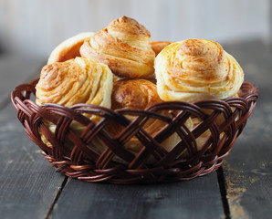 Homemade buns buns rich in a natural plate of vines on a dark wooden background. Holiday and everyday food.