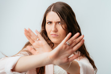 long-haired beautiful brunette girl shows her hands break his arms crossed isolated on white background