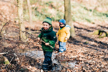 Jungen spielen mit Stöcken im Wald