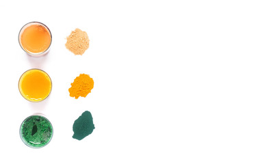 Ginger, turmeric, spirulina drink and powder omn white background. Copy space.