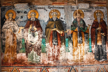 Mount Athos, Greece - October 21, 2019: Timeworn frescoes of saints on the outer side of the Church...