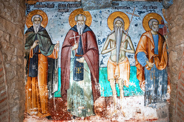 Mount Athos, Greece - October 21, 2019: Timeworn frescoes of saints on the outer side of the Church of Protaton in karyes, Mount Athos.. - obrazy, fototapety, plakaty