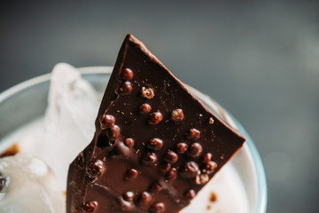 Creamy cocktail with ice and slice of chocolate. Selective focus. Shallow depth of field.