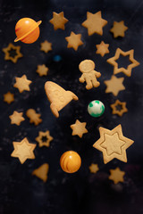Homemade Flying Cookies in form rocket, stars and astronaut for world cosmonautics day. Flying cookies on blue background. Selective focus, levitation. Space and astronomy concept