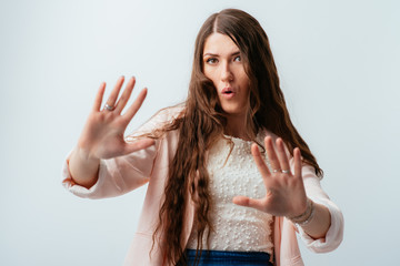 long-haired beautiful brunette girl holding hands at a distance, asked to calm down, isolated on a...