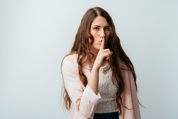 long-haired beautiful brunette girl asks quiet, isolated on a white background