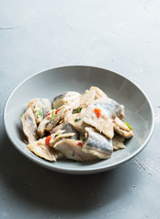 Marinated fish fillet with vegetables and spices on the rustic background. Selective focus. Shallow depth of field.