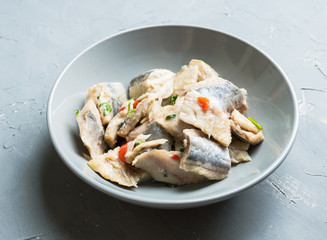 Marinated fish fillet with vegetables and spices on the rustic background. Selective focus. Shallow depth of field.