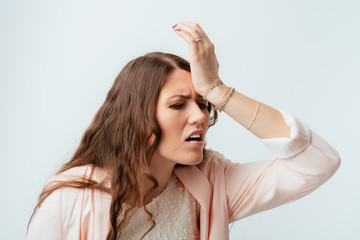 long-haired beautiful brunette girl made a mistake and holding his forehead