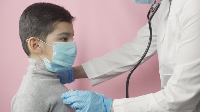 Typical health checkup before vaccination. Female doctor checking preschool boy. Child health, seasonal checkups during coronavirus outbreak quarantine time. Doctor visit
