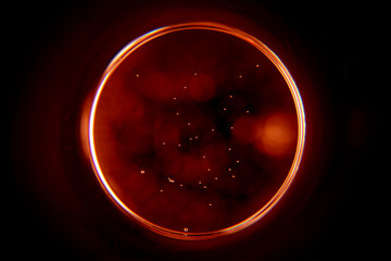 Abstract background with a black hole in red. Sphere on black background.