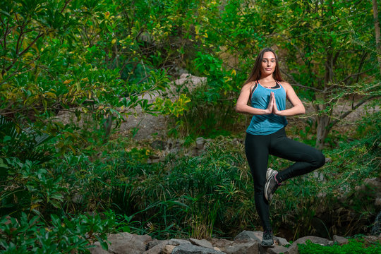 Young woman practicing yoga in the parck