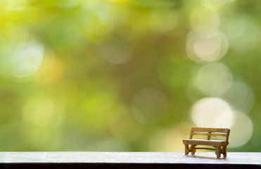 The wooden bench with Green Tree Bokeh in the Background for wallpaper
