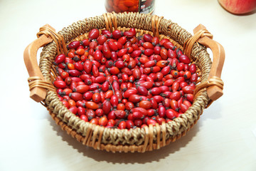red rose hips in basket . Fresh harvested rose hips in the basket. A basket of red rose hips ....