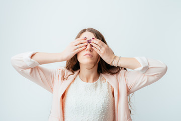 young woman covering her eyes with her hands