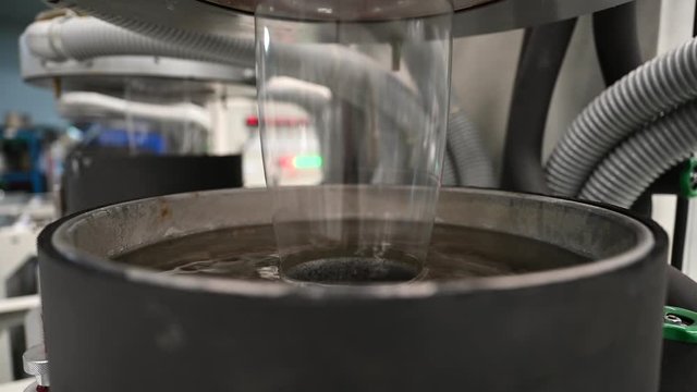 Plastic film making machine Polypropylene Closeup shows the clear plastic material flowing from the die head into a water tray with cold water to cool the plastic and make it beautiful.