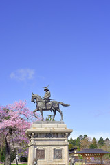 Obraz premium 桜と伊達政宗騎馬像