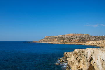 Cavo Greco cape on Cyprus. Travelling and vacation concept. Spectacular rocks on the Mediterranean Sea shoreline. Clean and blue cloudless sky