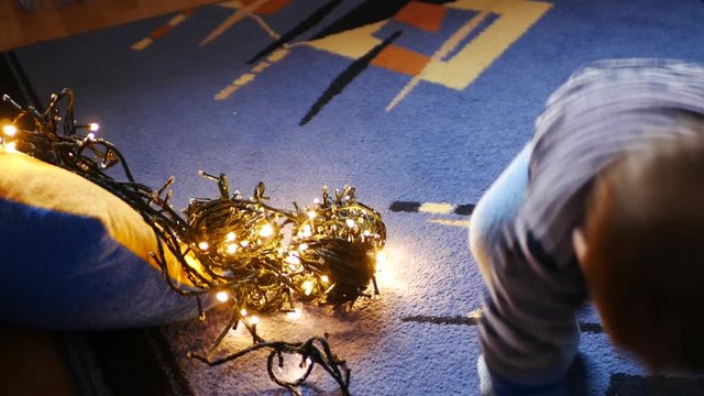 child plays with christmas garlands. child plays with christmas garlands