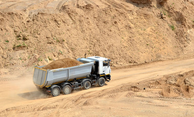 Dump truck transports sand and other minerals in the mining quarry.