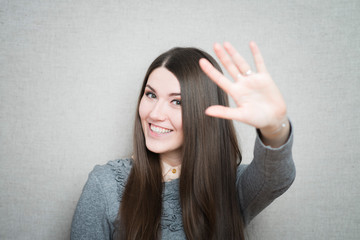 young woman waving, smiling
