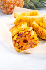 Heap of grilled pineapple slices on white background.