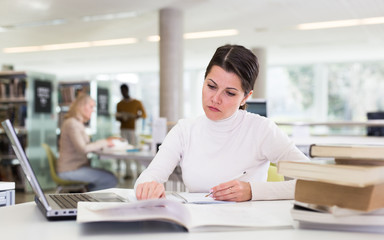 Fototapeta premium Successful woman studying in the library