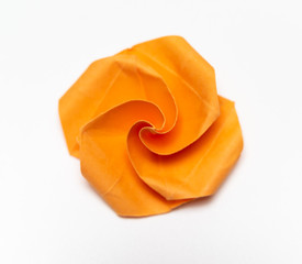 A single orange Origami paper flower as clipping from above.