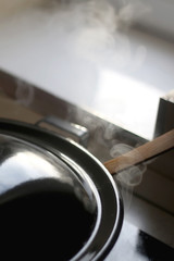 Fototapeta na wymiar Traditional wok with steam on a stove. Selective focus.