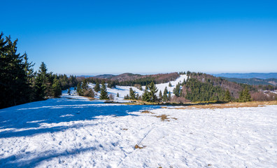 Meadows at the end of winter with snow and mountains in the background, beskydy czech