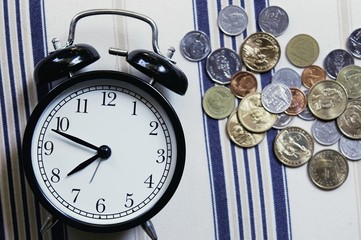 Vintage alarm clock and group of growing coins placed on the floor, selective focus and shallow depth of field, investment concept. growing on coin, Business Finance and Save Money.