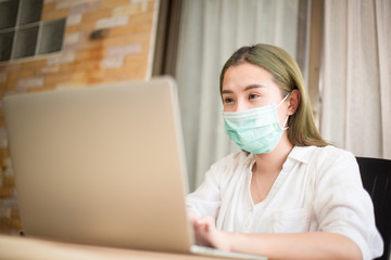 Corona virus. Young business woman working from home wearing protective mask. Business woman in quarantine for corona virus wearing protective mask. Working from home with sanitizer gel.