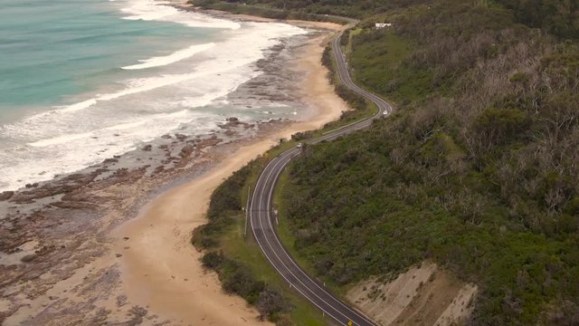 Cairns roadside beach DRONE aerial view. Turquoise ocean sea, white sand, road trip. Dramatic view from above. Travel, driving, road trip, holiday, vacation, paradise. Shot in Queenstown, Australia.