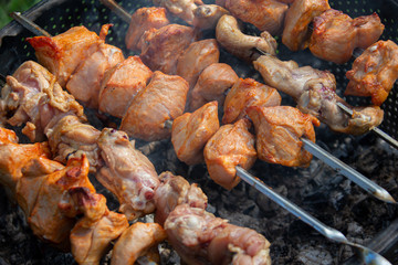 Chicken skewers on skewers in coals.