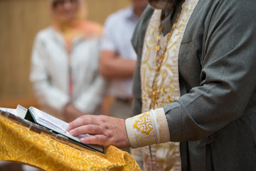 Hand of a priest with a bible.