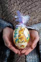Little kid is holding the Easter egg, made of paper – decoration for Easter holiday 