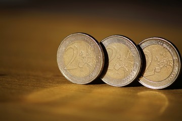 Two euro coins on wooden board