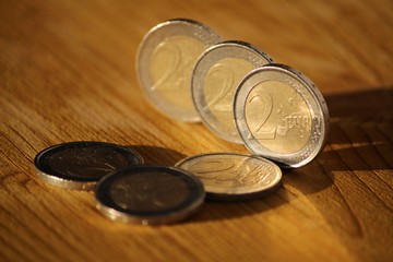 Two euro coins on wooden board
