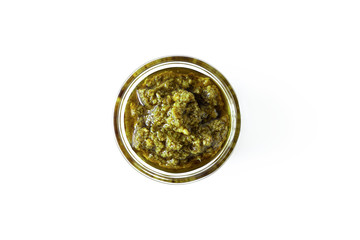 Basil italian pesto sauce in glass bowl isolated on white background, above. Seasoning and dip